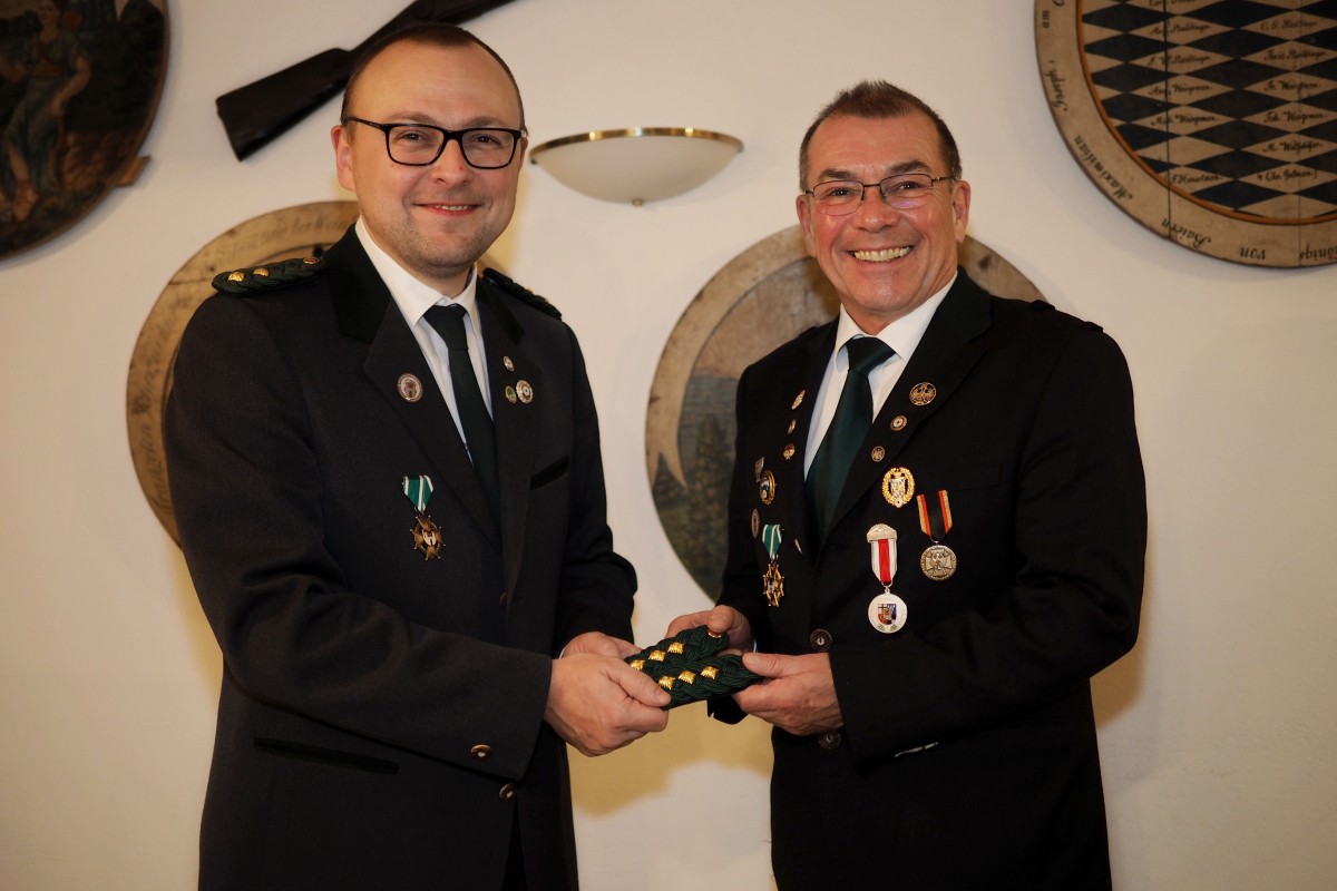 Das Bild zeigt den alten und den neuen 1. Schützenmeister, Jörg Raab (rechts) und Stefan Böbel bei der Übergabe der Schulterklappen